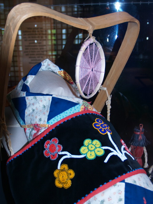 Traditional Ojibwe cradleboard with spider web dream-catcher